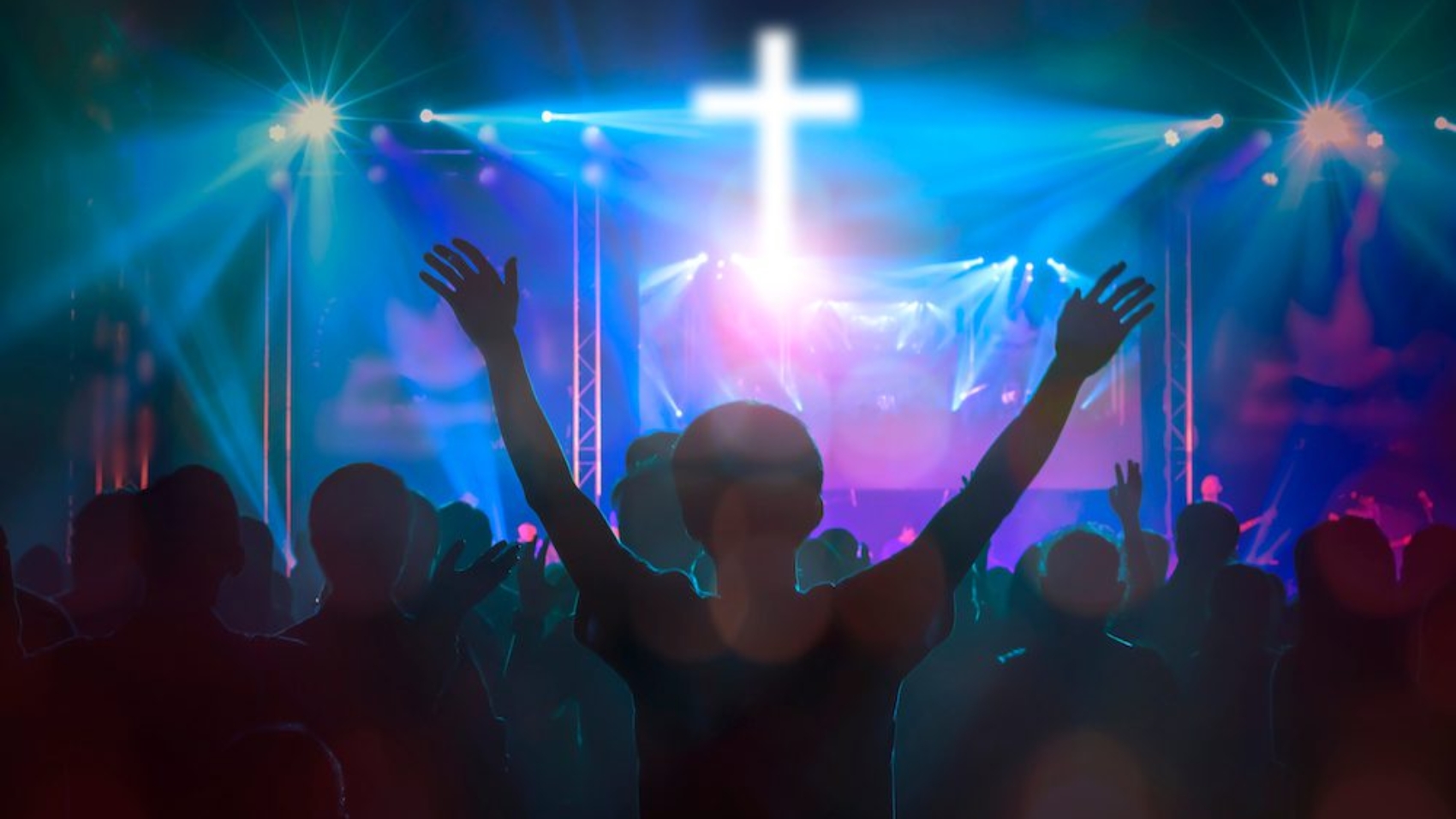 Christians raising their hands in praise and worship at cross background