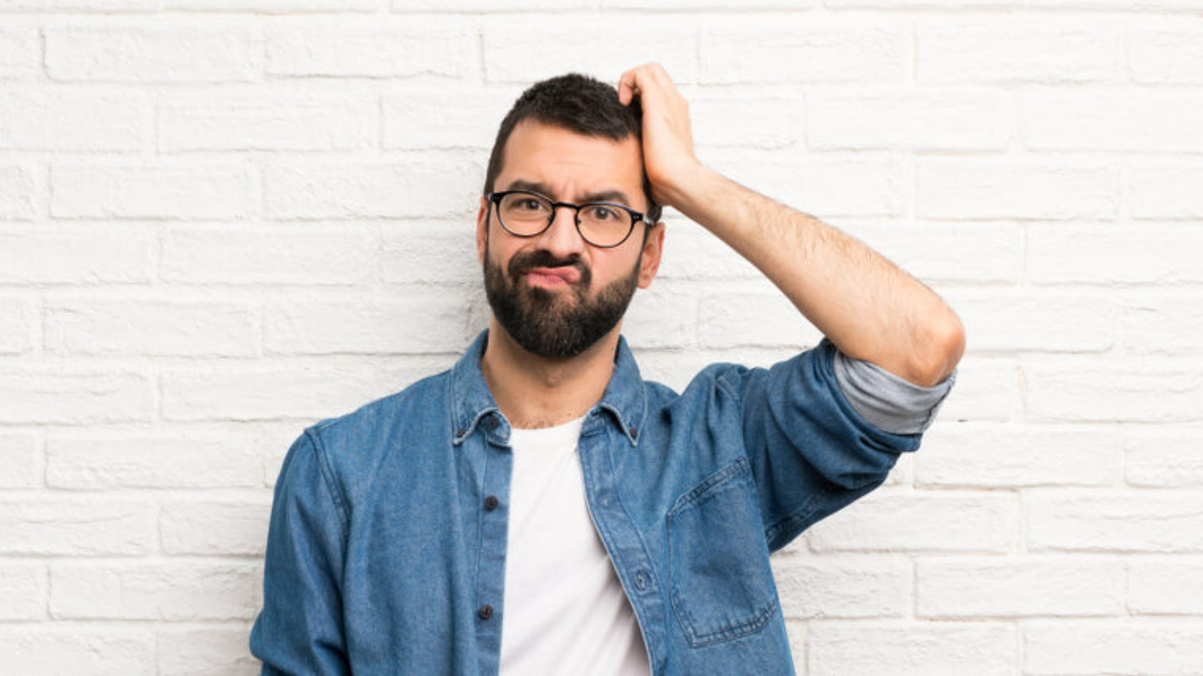 Handsome,Man,With,Beard,Over,White,Brick,Wall,With,An